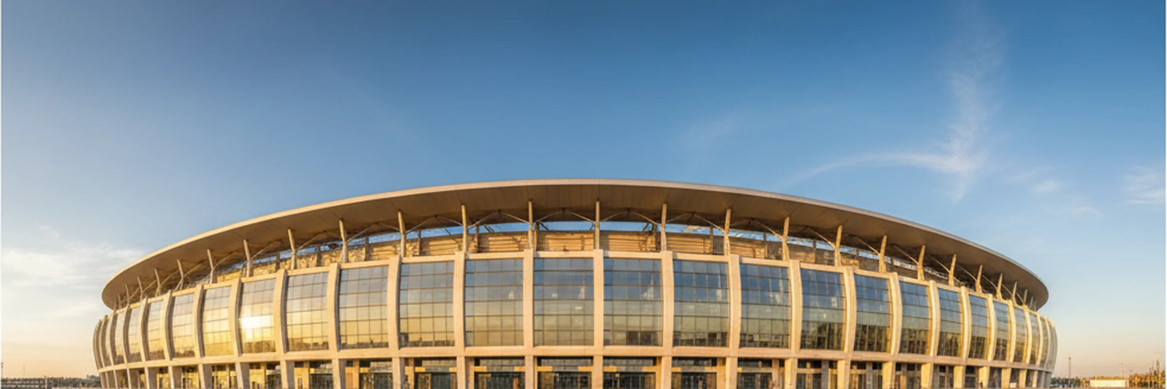 Modern stadium exterior facade in golden afternoon sunlight