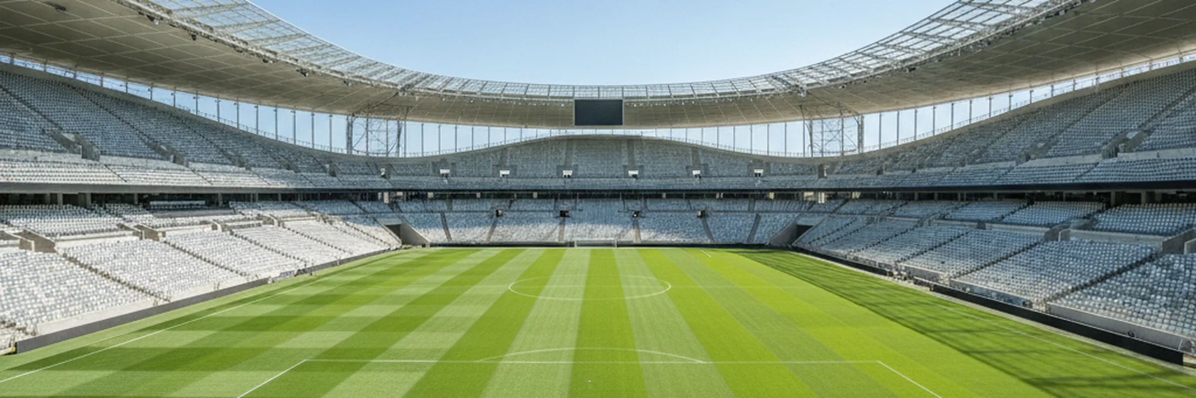 Sunlit modern football stadium interior with a vivid green pitch